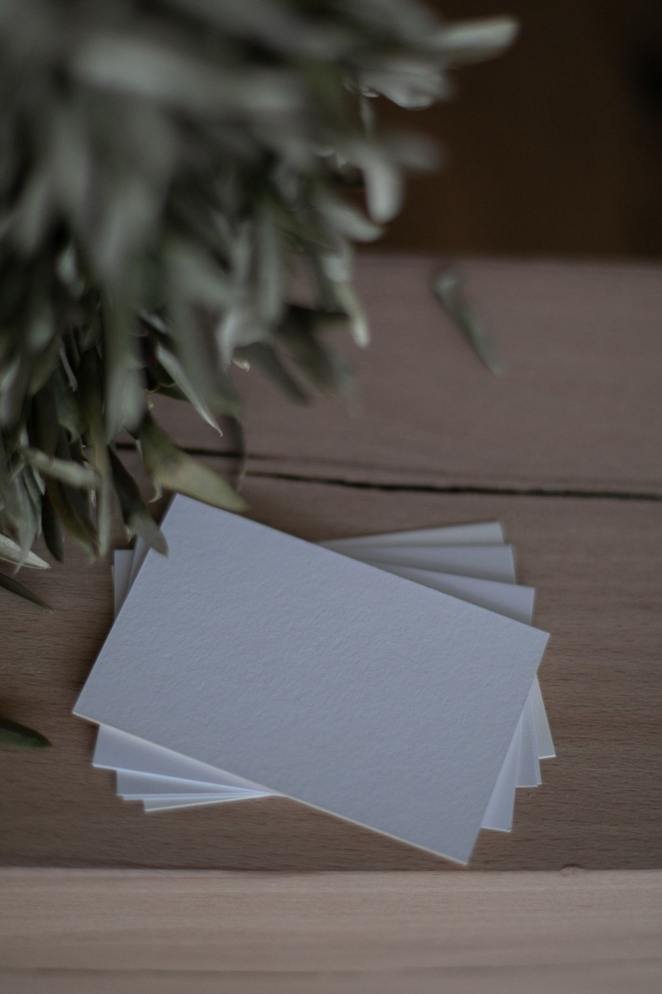 Chồng danh thiếp trắng trên mặt bàn gỗ